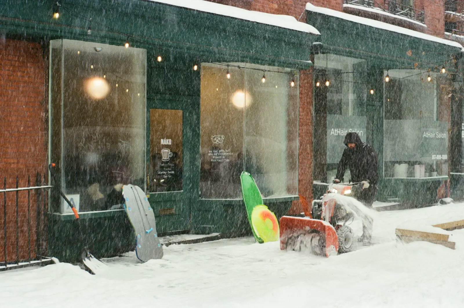 Manuelle Schneeräumung mit Schneefräse vor Geschäftslokalen